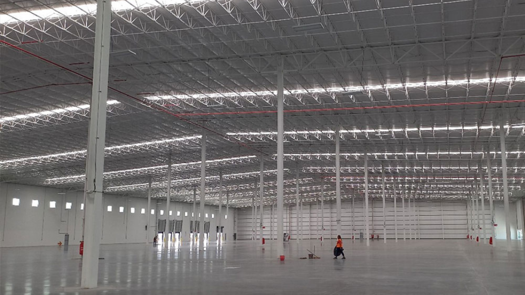 Inside a barebones core-shell warehouse with open floor, structural walls and roof